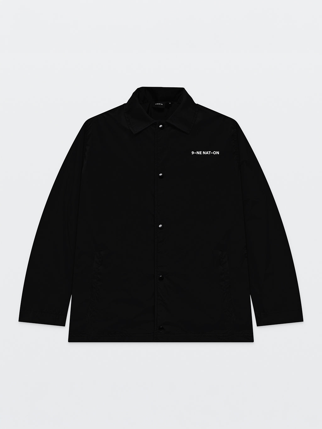 Front of the black 9INE Coach Jacket with a small 9INE NATION print on the chest